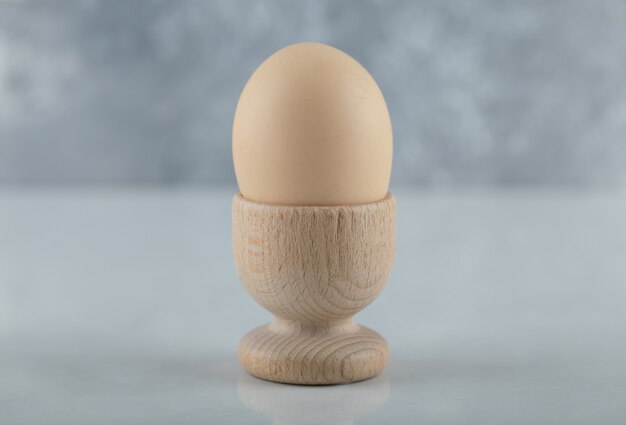 Close up photo of Boiled egg in eggcup on white background.