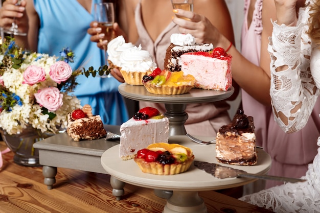 Close up photo of cakes and girls at party.