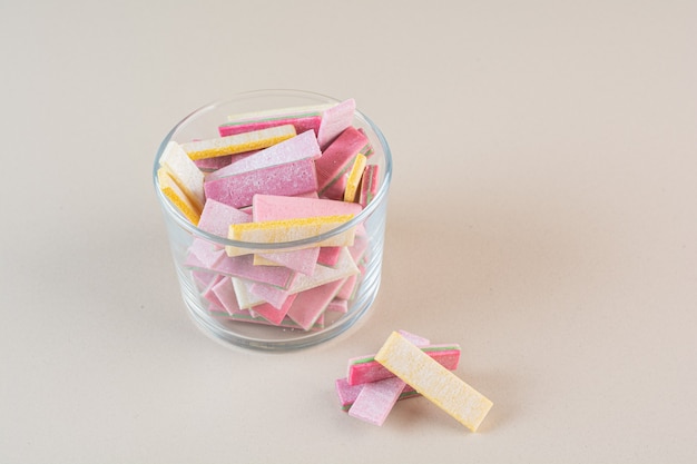 Free photo close up photo of colorful gums in glass bowl over cream.