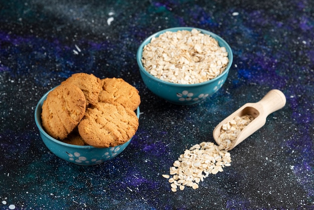 Foto gratuita foto ravvicinata di biscotti e farina d'avena in una ciotola sul tavolo scuro.