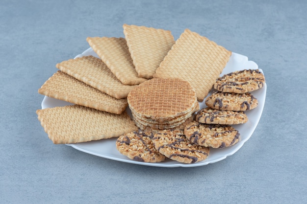 Close up photo of cookies on white plate. Various kinds of cookies