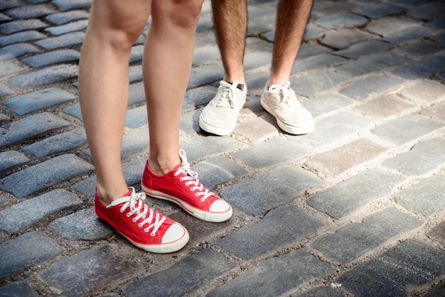 Close up photo of couple's legs in keds standing at street