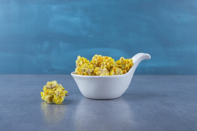 Free photo close up photo of dry healthy herbs in white bowl.