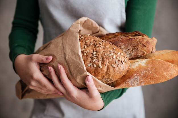 Close up photo of female baker holding bag with bread