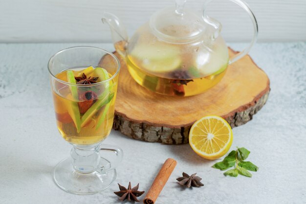 Close up photo of Fresh apple cocktail on grey surface with cocktail pot .