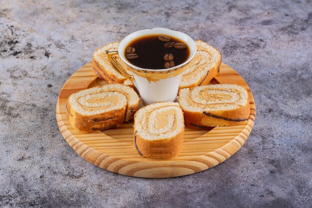 close up photo of fresh cake rolls with cup of coffee.