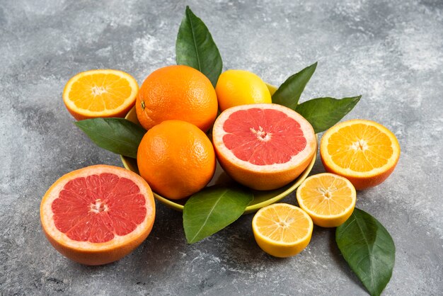 Close up photo of fresh citrus fruits in bowl. Whole or half cut.