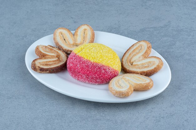 Close up photo of fresh cookies on white plate on grey background.