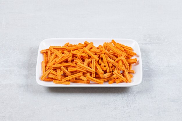 Close up photo of fresh fries on white plate.