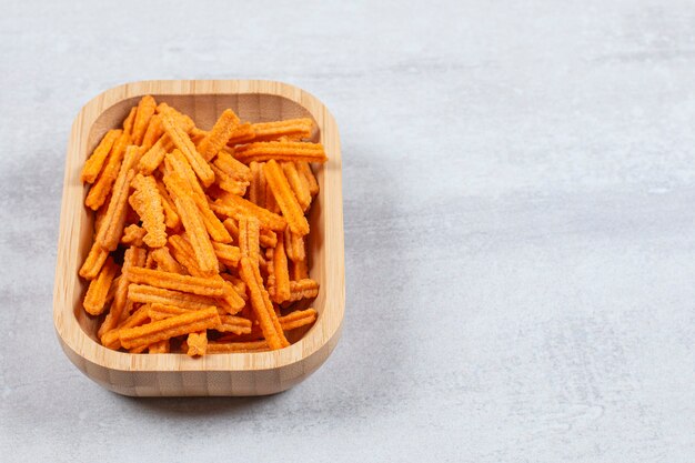 Close up photo of fresh fries in wooden bowl.