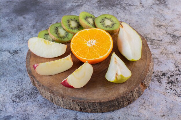 Close up photo of fresh fruit slices on wooden board.