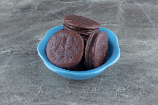 Close up photo of Fresh homemade chocolate cookies on blue bowl.
