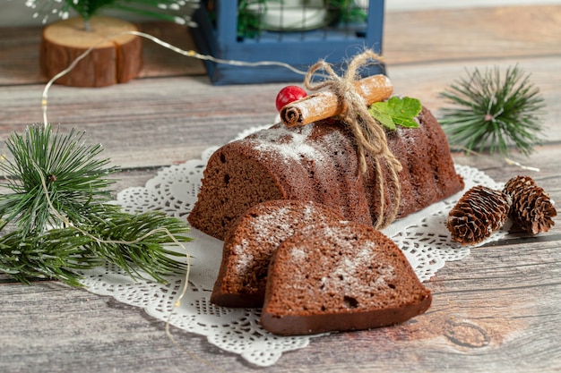 Foto gratuita foto ravvicinata di cioccolato fresco fatto in casa intero e affettato su tavola di legno.