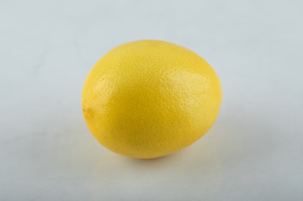 Крупным планом фото свежего лимона на белом фоне.