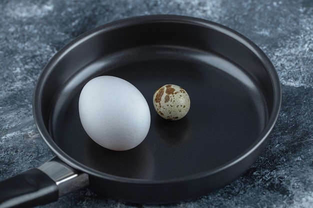 Закройте вверх по фото свежего органического куриного яйца с перепелиными яйцами.