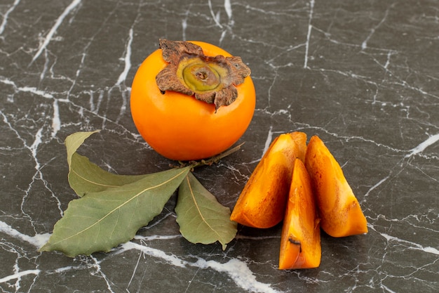 Close up photo of fresh organic persimmons. whole or sliced.