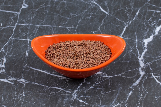 Free photo close up photo of fresh raw buckwheat in orange bowl.