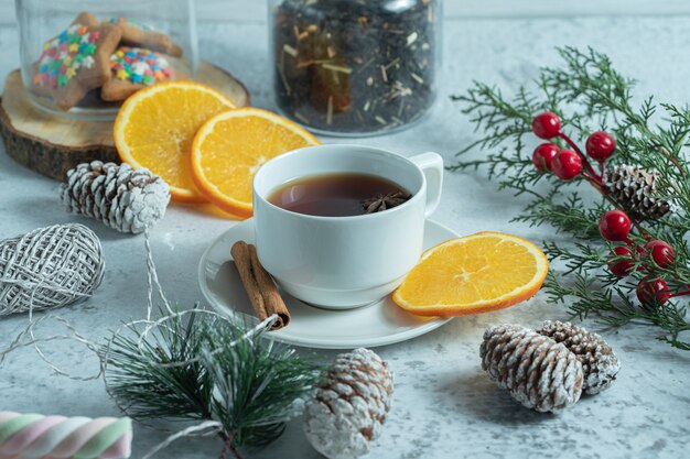 Крупным планом фото свежего чая с дольками апельсина.