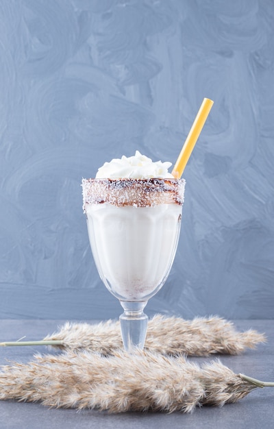 Close up photo of Freshly made milk shake on grey background.