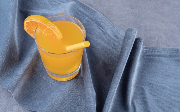 Close up photo of Freshly made orange juice on grey background.