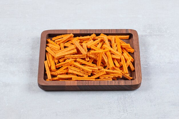 Close up photo of fries on wooden plate.