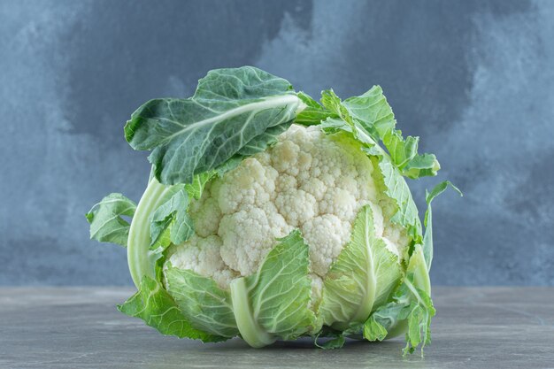 Close up photo of green fresh Cauliflower on grey table.