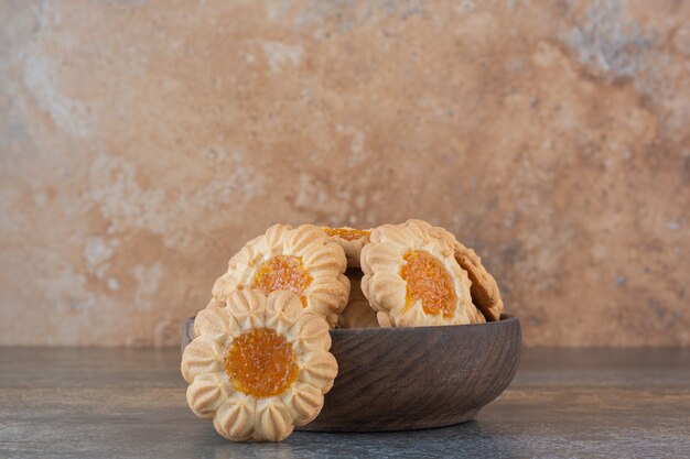 Крупным планом фото домашнего печенья с вареньем в деревянной миске над деревенским