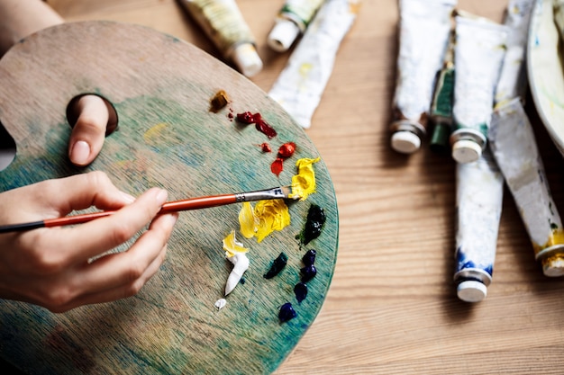 Close up photo of mixing oil paints on palette