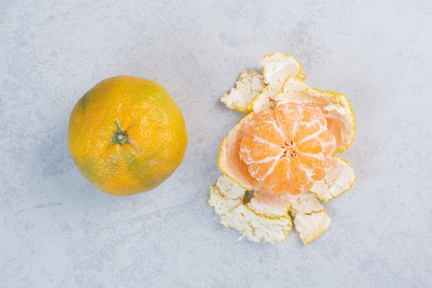 Close up photo of peeled and whole tangerine. 