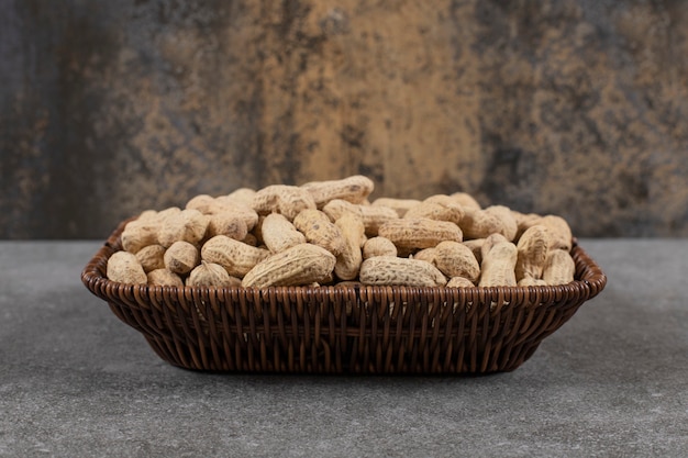 Free photo close up photo of pile of peanuts in shell in basket