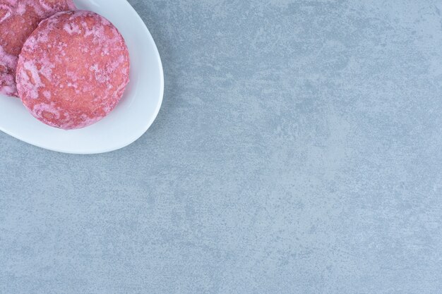 Close up photo of pink cookies in white plate. Free Photo