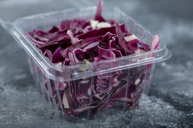 Close up photo of plastic container full with chopped purple cabbage