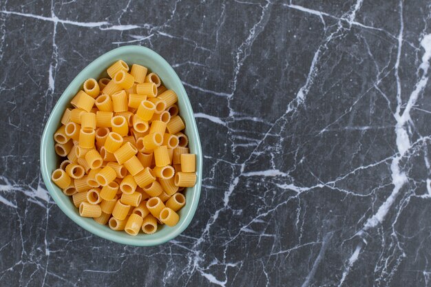 Close up photo of raw penne pasta.