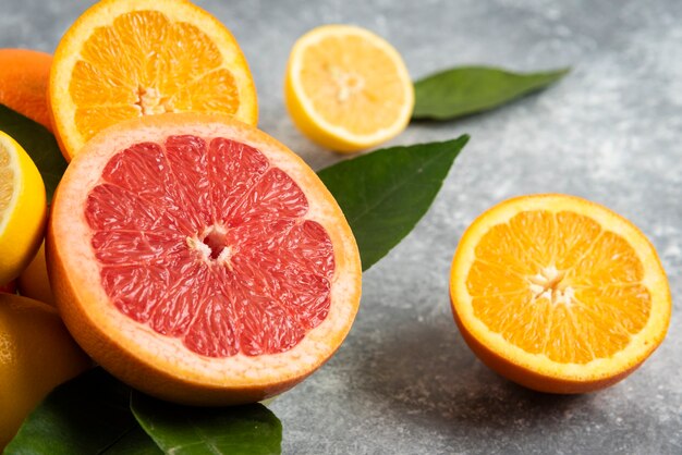 Close up photo of sliced citrus fruits on grey surface. 