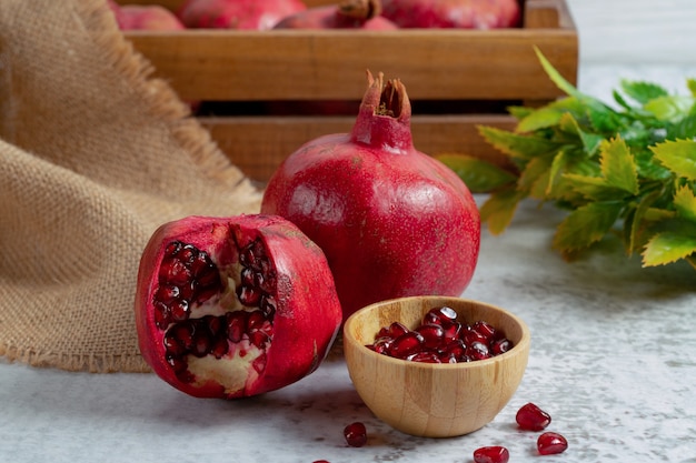 Close up photo of sliced or whole pomegranate over grey backround.