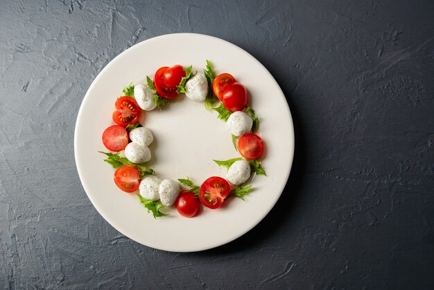 Close-up photo top view of plate with caprese salad, restaurant arrangement of food