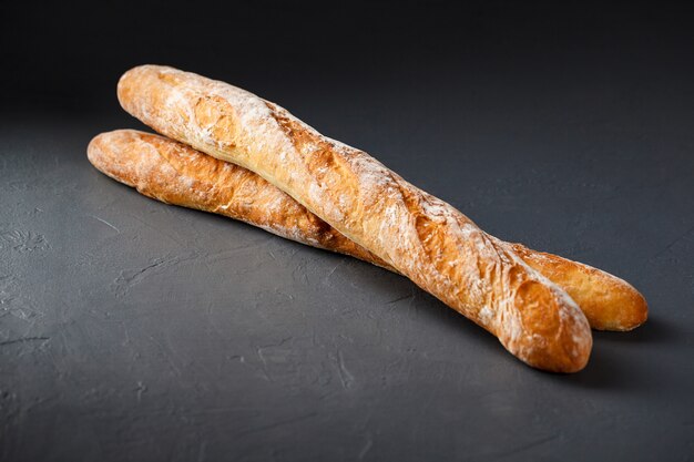 Close-up photo of two french baguettes on gray surface