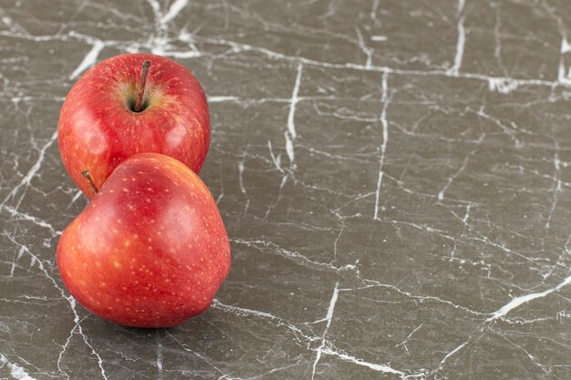 Close up photo of Two fresh apple on grey stone.