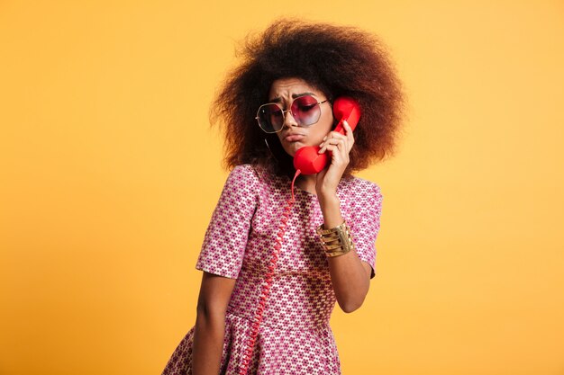 Close-up photo of upset retro girl with afro hairstyle posing with retro phone