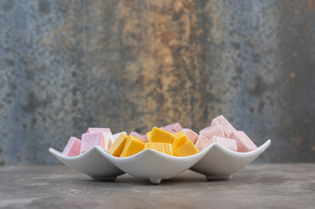 Close up photo of white plate full with colorful candies .