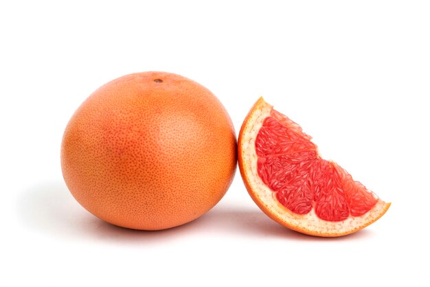 Закройте вверх по фото целого или нарезанного грейпфрута, изолированного на белом.