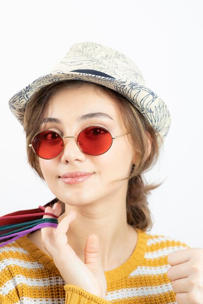 다채로운 쇼핑백을 들고 선글라스에 젊은 갈색 머리 여자의 사진을 닫습니다. 고품질 사진