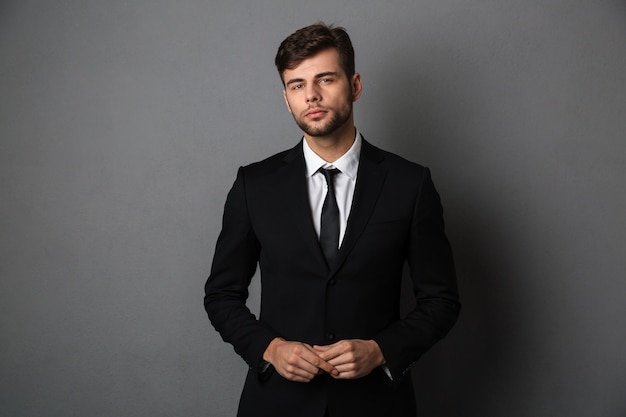 Close-up photo of young successful business man in black suit 