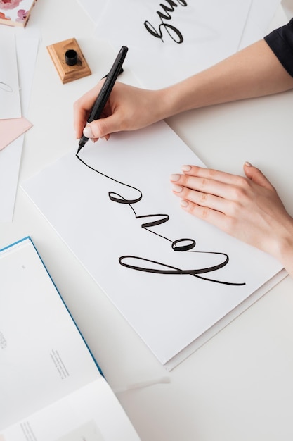 Close up photo of young woman hands writing cute notes on paper on desk isolated