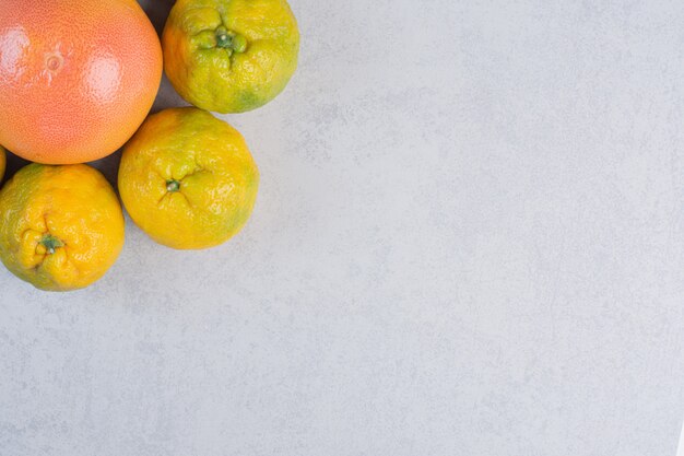 Close up photos of Tangerines (oranges, clementines, citrus fruits) over grey background . 