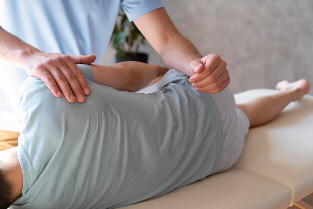 Close up physiotherapist helping patient with pain