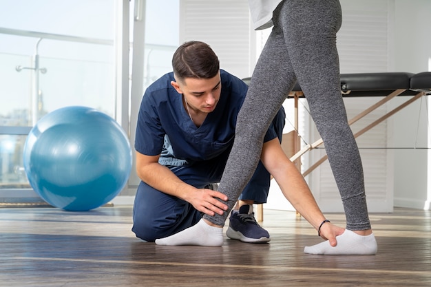 Close up physiotherapist helping patient