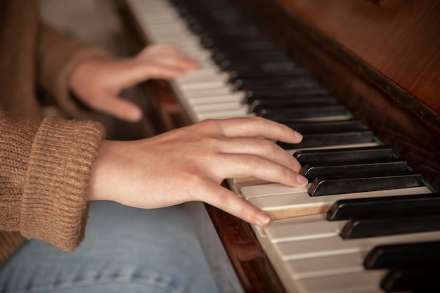 Close-up of a pianist's hands on the piano keys, female hands playing the piano.