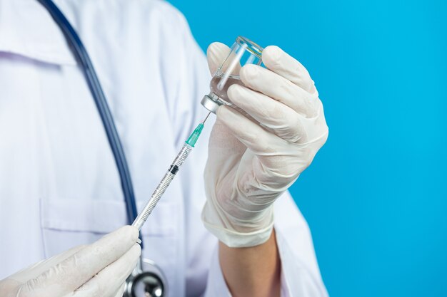 Close up picture of docter's  hands holding hypodermic syringe