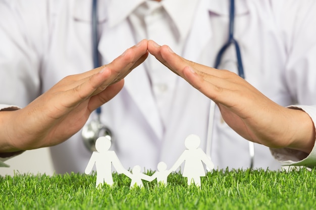 Free Photo close up picture of doctor's hands posting symbol of home above family member model